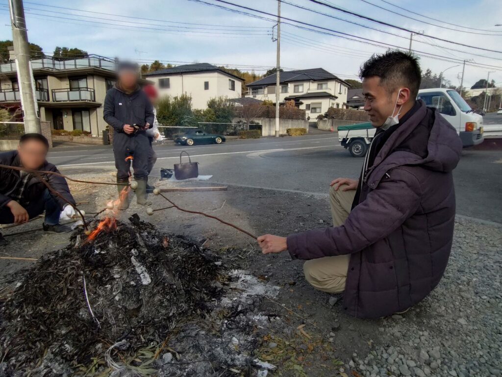 どんど焼きでお団子を焼くさかす編集長