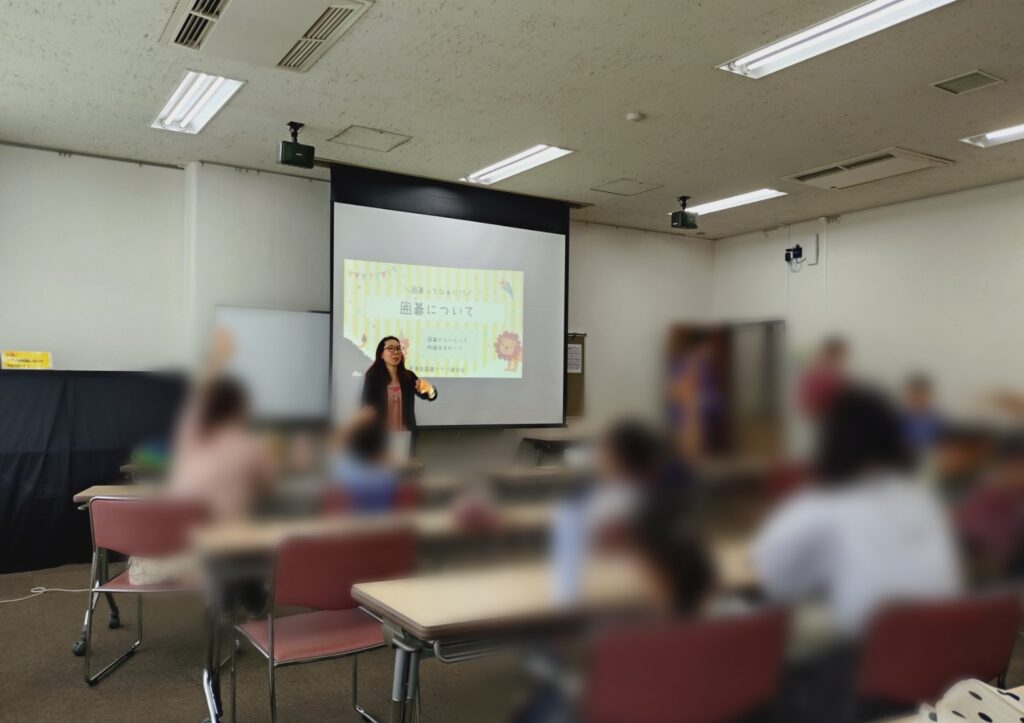 座学で囲碁の基本ルールを教わるお子さんと保護者の方々