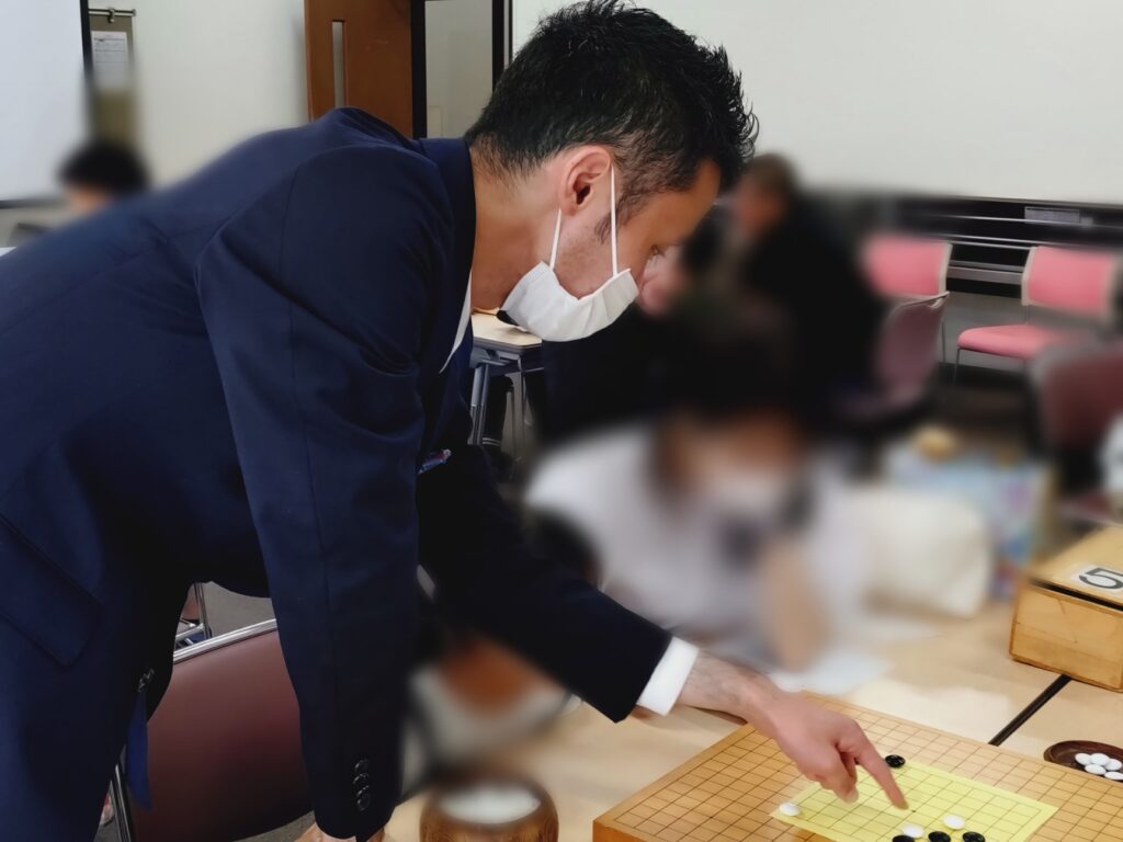 盤面を指しながら助言するサカス編集長