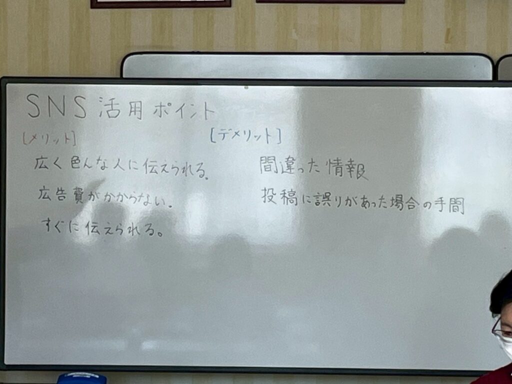 SNS活用のメリットとデメリットをホワイトボードに書き出した様子。