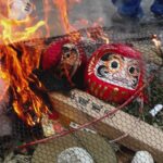 どんど焼きの火にくべられるダルマ