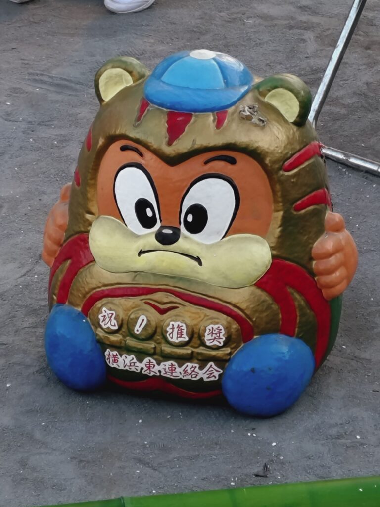 たぬきのようなキャラクターを模した大きな張り子のだるま