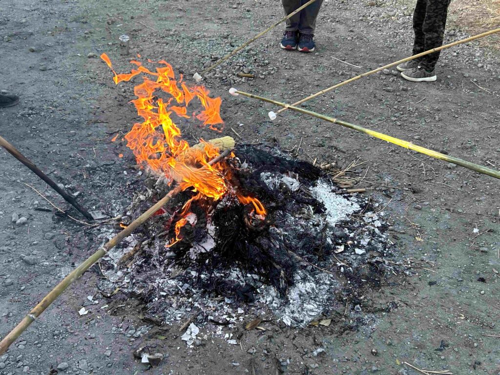 燃え残っているしめ縄と、焚き火でマシュマロを焼く様子