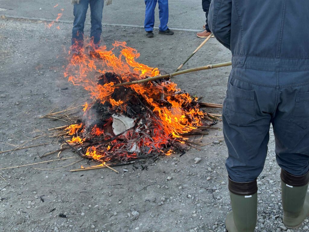 距離を取りながら火の勢いの調整を行う自治会員の方々