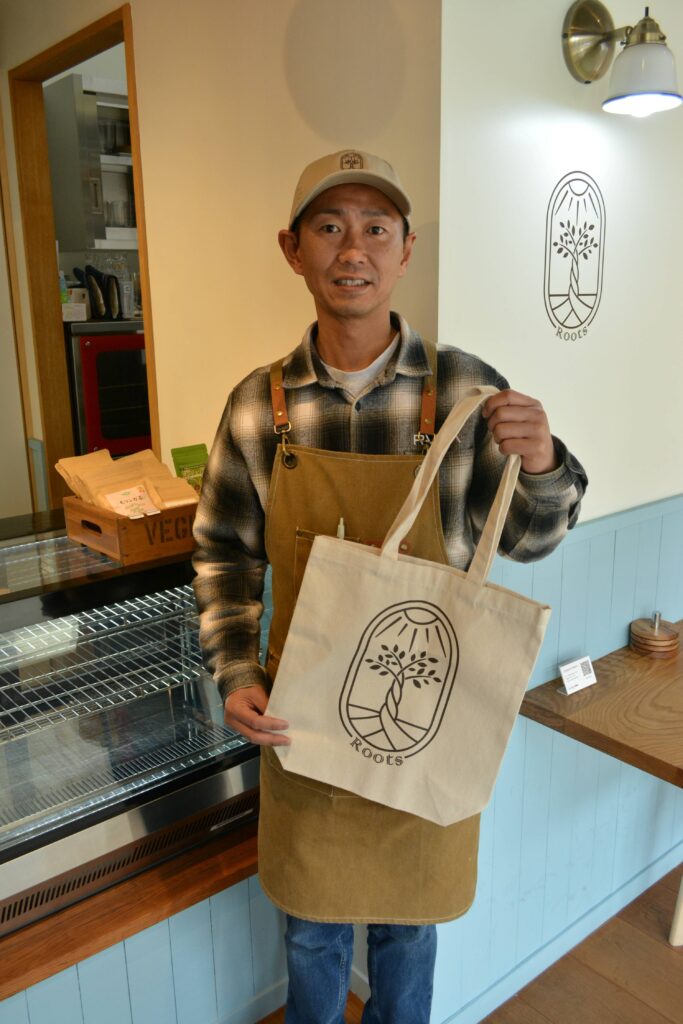 トートバッグを手に微笑む田島さん