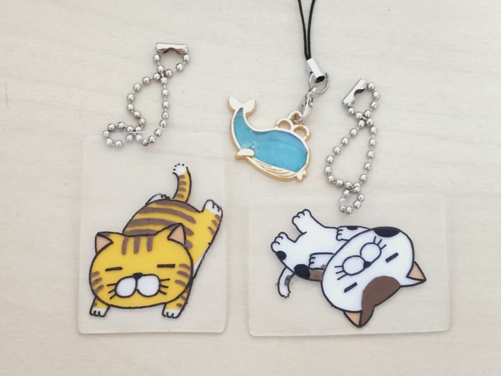 スタッフさんオリジナルの猫のイラストのプラバンキーホルダーと、レジンアートのキーストラップ