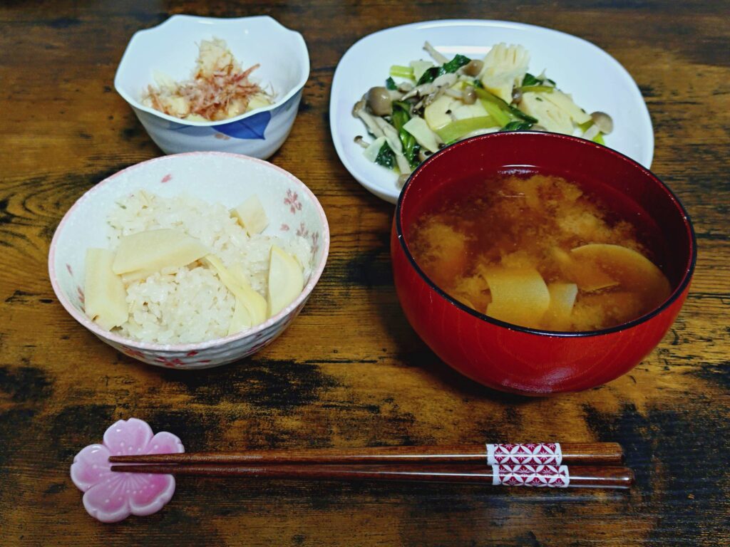 タケノコ料理が並んだ食卓（左下から反時計回りに、タケノコごはん、味噌汁、炒めもの、小鉢）
