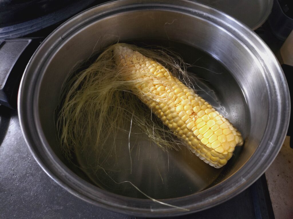水から湯がいているトウモロコシ